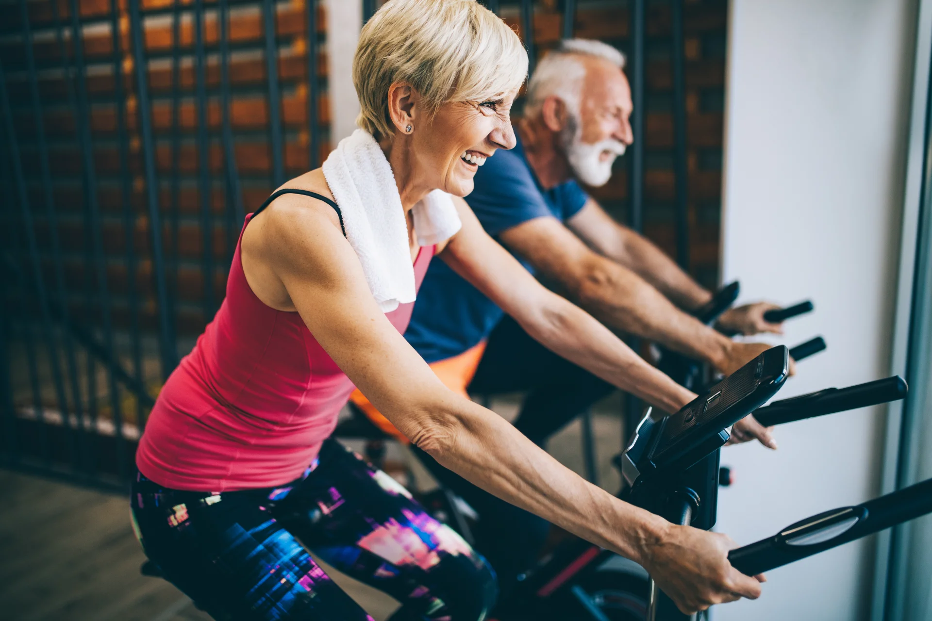 man and woman using exercise bikes